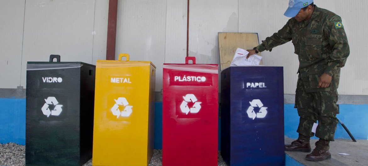 Un casco azul de la Misión de la ONU en Haití separa los desechos para reciclar.