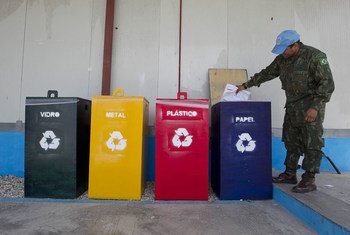 A peacekeeper with the UN mission in Haiti (MINUSTAH) drops paper into a recycling bin at the Mission. Recycling of metal, plastic, paper and glass helps cut back on the waste which would have otherwise ended up in landfills.