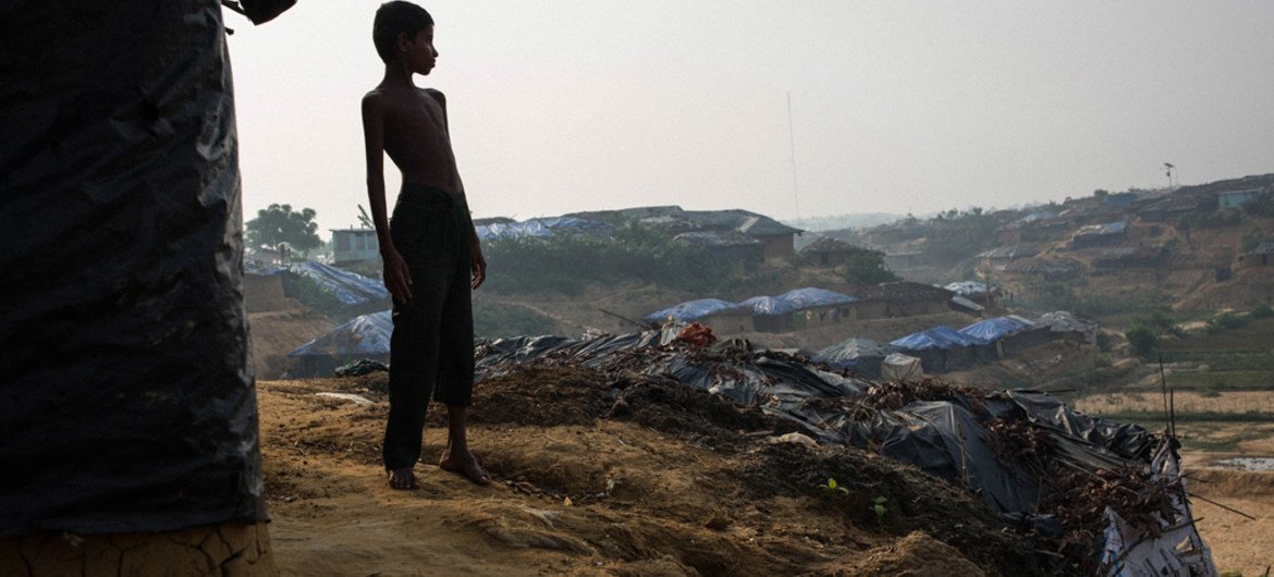 在孟加拉国的一个国内流离失所者营地，一名八岁的小孩在逃离缅甸残暴的暴力和迫害之后，站在与家人同住的一间泥屋外。图片：儿基会 / Nybo