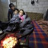 叙利亚霍尔姆斯的一处非正式定居点，一户家庭正在一栋尚未完工的房屋内生火取暖。（资料图片）