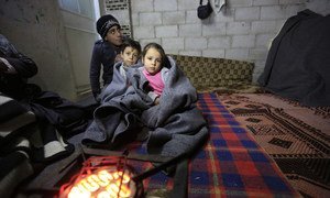 A Syrian family tries to keep warm in this unfinished building in the informal settlement of Al-Khalidia Al-Khamisa in Homs. UNICEF/Sanadiki (file)