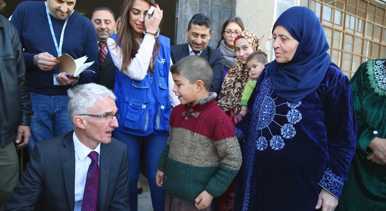 مارك لوكوك منسق الأمم المتحدة للإغاثة الطارئة يتحدث في حمص مع الطفل خالد، 10 سنوات، الذي نزح مع أسرته من تدمر -أرشيف