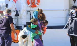 A woman carries her two babies as she disembarks the boat that rescued her while attempting to cross the Mediterranean Sea from Libya to Italy. (file) UNHCR/Francesco Malavolta