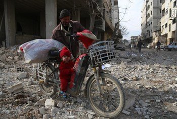 Ru’a, 18 months, rides on her grandfather’s motorbike as he drags it across Mesraba in East Ghouta, Syria.