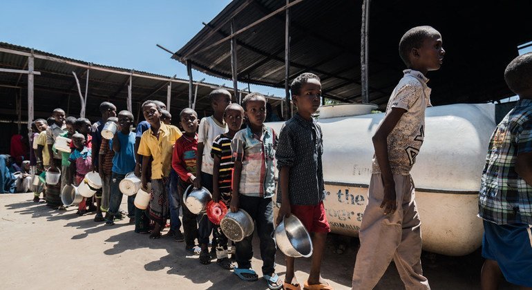 Niños desplazados internos en Mogadishu, Somalia esperan en línea para recibir comida del Programa Mundial de Alimentos.