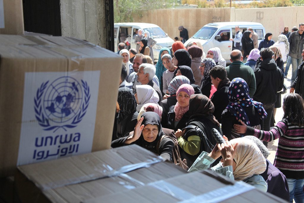 在叙利亚大马士革近东救济工程处分发中心排队领取粮食救济的巴勒斯坦难民。