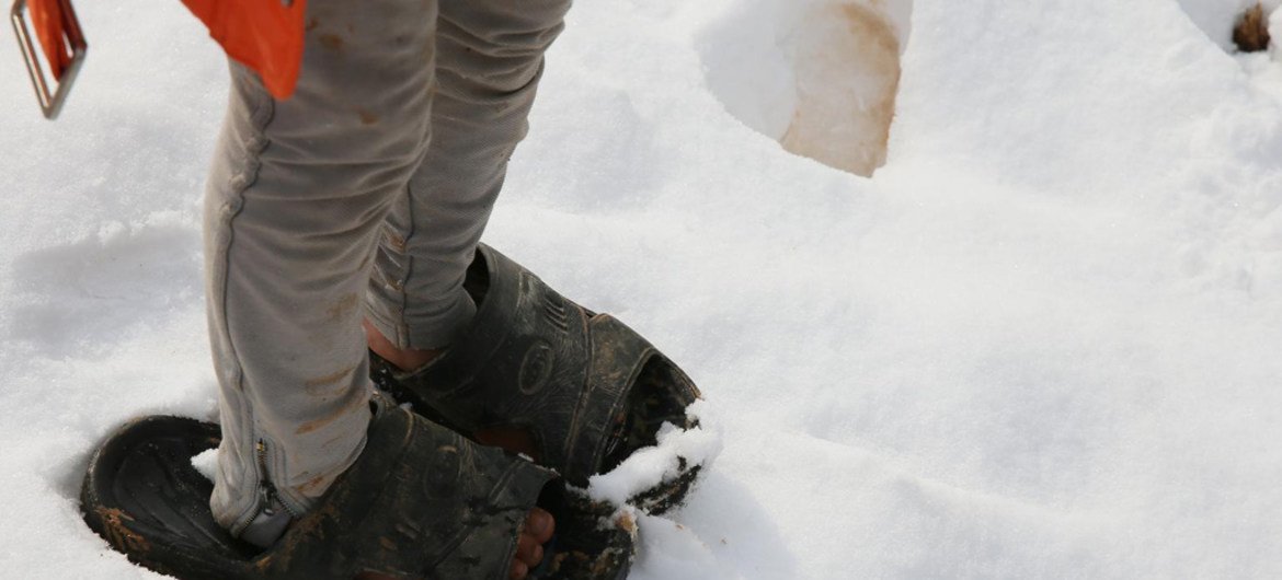 صورة من الأرشيف لطفل من أسرة لاجئة سورية ينتعل حذاء غير مناسب للثلج.