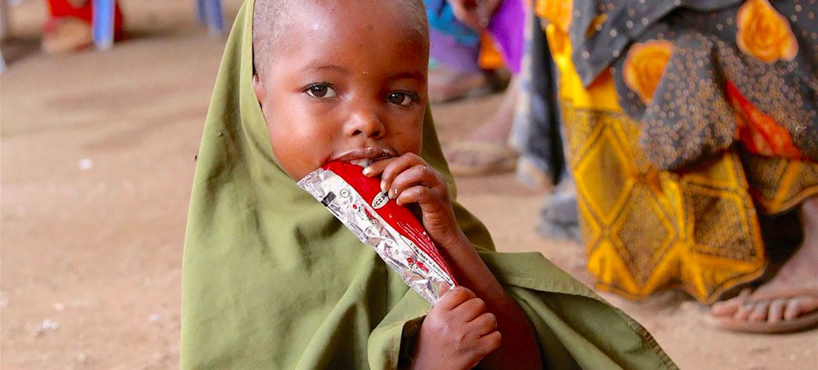 Menino de quatro anos come barra energética, parte do tratamento contra desnutrição do Unicef na Somália. 