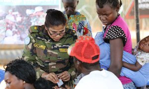 Los miembros de estos contingentes desempeñan distintas funciones en las misiones de paz. Fotografía de una oficial pasando consulta médica a los residentes de una comunidad en la República Centroafricana.
