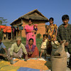 Une famille d'agriculteurs étalent des céréales pour les faire sécher à l'extérieur de leur maison dans le district de Chitwan, dans le  centre du Népal.