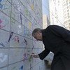 أرشيف فبراير 2018: الأمين العام أنطونيو غوتيريش يكتب على حائط الهدنة الأولمبية في بيونغ تشانغ أثناء دورة الألعاب الأولمبية الشتوية في كوريا الجنوبية.