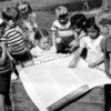 Young children read the Universal Declaration of Human Rights at a playground. (Archive)