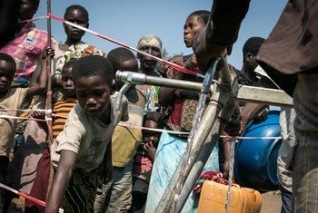 Children gather at a water point at Moni site for internally displaced persons in Kalemie, Democratic Republic of the Congo, hosting more than 20,000 people. Photo: OCHA/Ivo Brandau