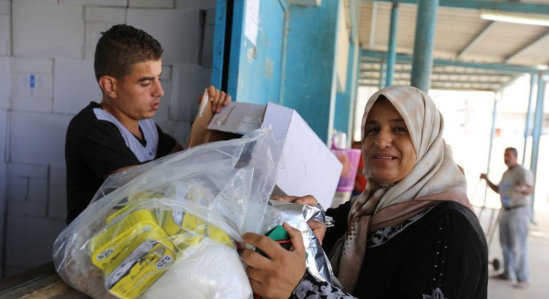 Una refugiada palestina recibe ayuda de la UNRWA en un centro de Gaza