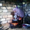 شأنها شأن الكثيرين في غزة، لاجئة فلسطينية  تقوم بالطهي و الغسيل والتدفئة بذات الموقد نتيجة فقر الامكانات - مخيم الشاطئ -غزة