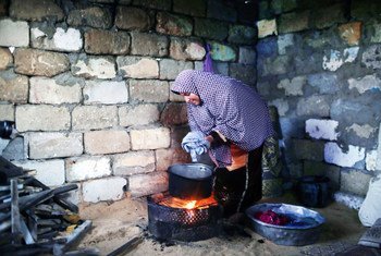 شأنها شأن الكثيرين في غزة، لاجئة فلسطينية  تقوم بالطهي و الغسيل والتدفئة بذات الموقد نتيجة فقر الامكانات - مخيم الشاطئ -غزة