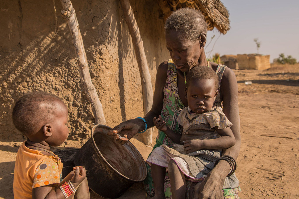 Une mère nourrit ses enfants avec du sorgho au Soudan du Sud.