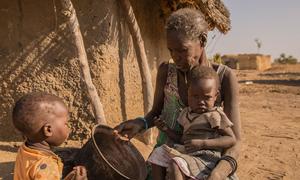 Une mère nourrit ses enfants avec du sorgho au Soudan du Sud.