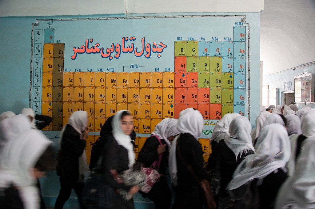 Des étudiantes en Afghanistan devant le tableau périodique des éléments chimiques.