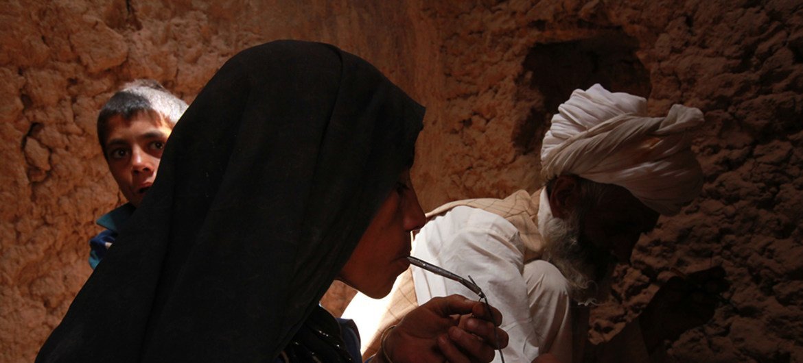 Una mujer afgana fuma heroína con su marido y su hijo en una cueva de Islam Qala, Herat.