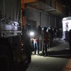 عمال الإغاثة يعملون خلال الليل لتحميل مساعدات إنسانية على متن شاحنات متجهة إلى الغوطة الشرقية، سوريا في شهر سبتمبر/أيلول 2017.