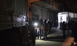 In this September 2017 photograph, humanitarians work through the night to load relief supplies onto an inter-agency convoy bound for east Ghouta, Syria.