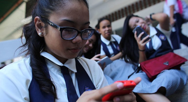Menina verifica seu smartphones nas Filipinas