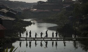 A group of Rohingya refugee children gather at sunset on a bamboo bridge in Kutupalong makeshift settlement, Cox's Bazar District, Bangladesh, 11 January 2018.