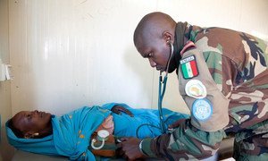Le docteur Lt. Famara Seck, Casque bleu, assiste un patient local à la clinique de la base de l'équipe sénégalaise à Um Baro, dans le nord du Darfour.