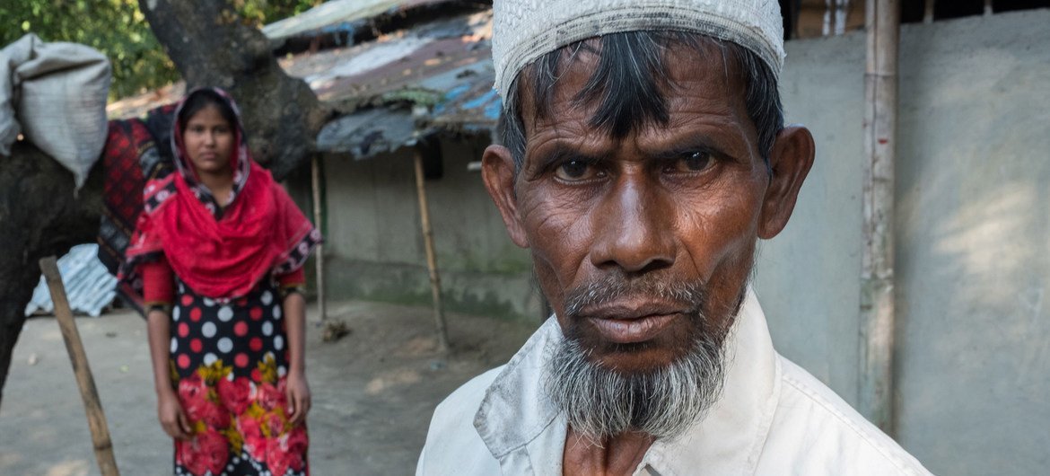 Farmer Nurul Haque stands near his 13-year-old daughter in Bangladesh, saying he may have to pull her from school and marry her off to an older man because he has few financial options left.