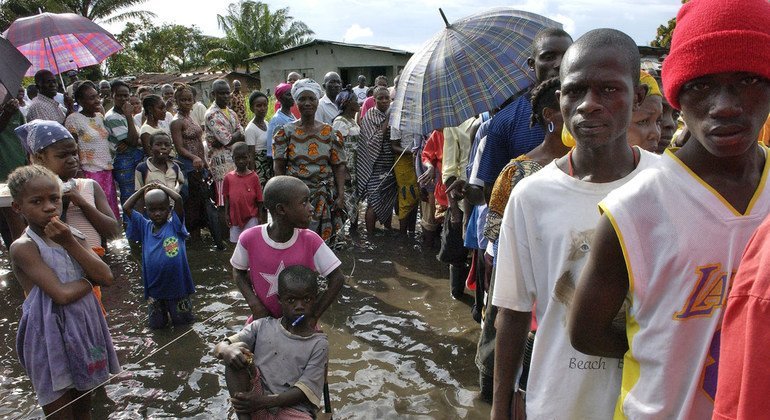 Liberian voters in Doe Township stand in knee-deep water waiting to cast their vote in the first democratic election since the end of the civil war. 