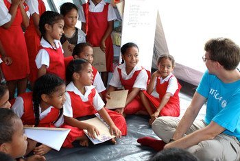 A UNICEF official interacts with school children in a tent provided by the UN agency so that they can they continue their studies in the wake of Cyclone Gita in Tonga.