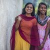 Duas adolescentes na índia posam para fotos em frente ao vilarejo onde vivem. 