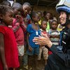 Miembro de la Misión de la ONU en Liberia comparte con una niña en el campamento de Steward, antes de terminar su mandato.