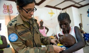 Una médica pakistaní que sirve con la misión de la ONU en Libia examina a un niño durante una guardia de maternidad en Tubmanburg, en febrero de 2009.