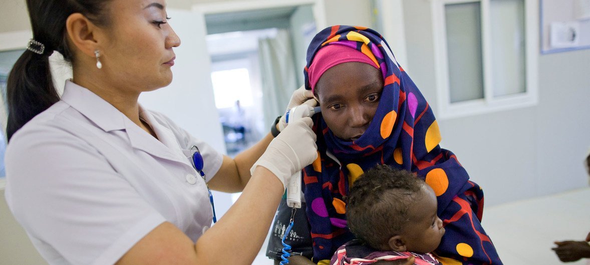 A nurse from the Mongolian Hospital Unit in Darfur treats a mother and child (10 December 2012).