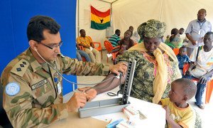 Un membre du contingent pakistanais de l'Opération des Nations Unies en Côte d'Ivoire (ONUCI) dispense des consultations médicales à des civils à Korhogo, en mai 2014. 