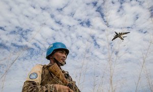 Un miembro del personal de mantenimiento de la paz mongol garantiza la seguridad mientras el Programa Mundial de Alimentos entrega alimentos en Bentiu, Sudán del Sur (21 de octubre de 2015).