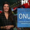 Apresentadora de notícias Denise Costa em um estúdio com o logotipo da ONU News ao fundo.