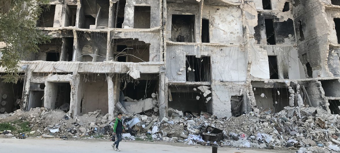 A boy walks past severely destroyed houses in a neighborhood in eastern Aleppo, Syria. 