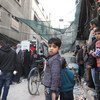 سكان من الغوطة، بمن فيهم أطفال، يصطفون لاستلام المساعدات الغذائية التي دخلت إلى دوما في الخامس من آذار