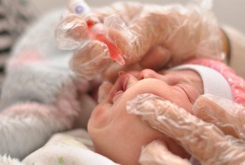 Trabajadores sanitarios vacunan a un bebé contra el sarampión. 