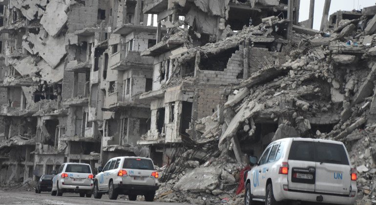 Convoyes de UNICEF circulan ante los edificios derruidos de Homs, en Siria.   