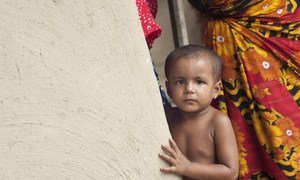 孟加拉国农村地区一名儿童站在墙壁旁。