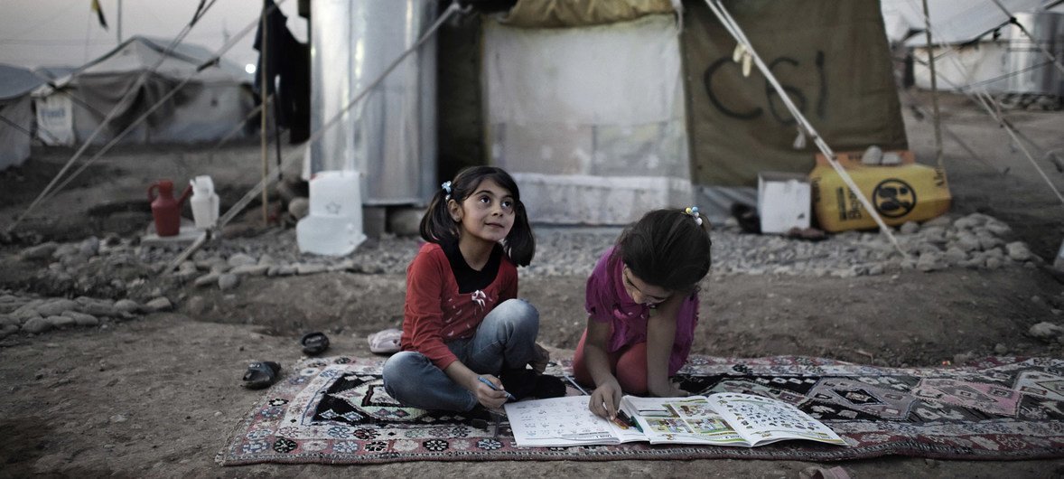 伊拉克北部库尔德斯坦首府埃尔比勒（Erbil）以西的卡沃格斯科叙利亚难民营（Kawergosk），两个女孩正在帐篷外面做作业。