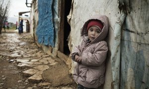 An 18-month-old toddler stands outside a tent where she lives with her family in Saadnayel Camp, an informal tented settlement where Syrian refugees are sheltering, in the Bekaa Valley, Lebanon.