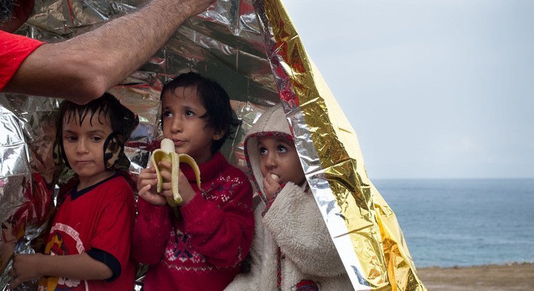 Tres niñas refugiadas se resguardan bajo una manta de emergencia tras llegar a las costas de Lesbos, en Grecia.