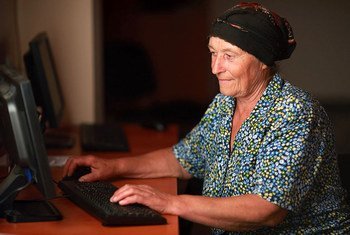 Женщина в Грузии осваивает работу с компьютером. 