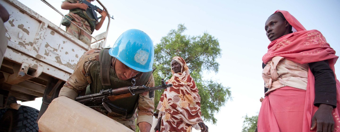 Las fuerzas de paz egipcias, junto con la Operación Híbrida de la Unión Africana y las Naciones Unidas en Darfur, distribuyen agua y harina a la población local en la localidad de Um Kadada en septiembre de 2011.