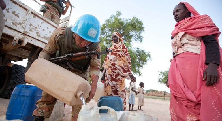 Egyptian peacekeepers with UNAMID distribute water and flour to the local population in Um Kadada (North Darfur) in September 2011.